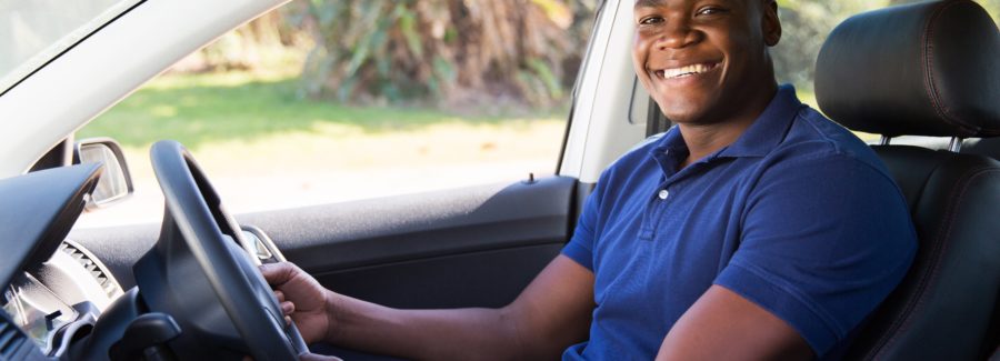 cheerful african man inside his new car